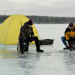 Два рибалки ловлять рибу на льоду.