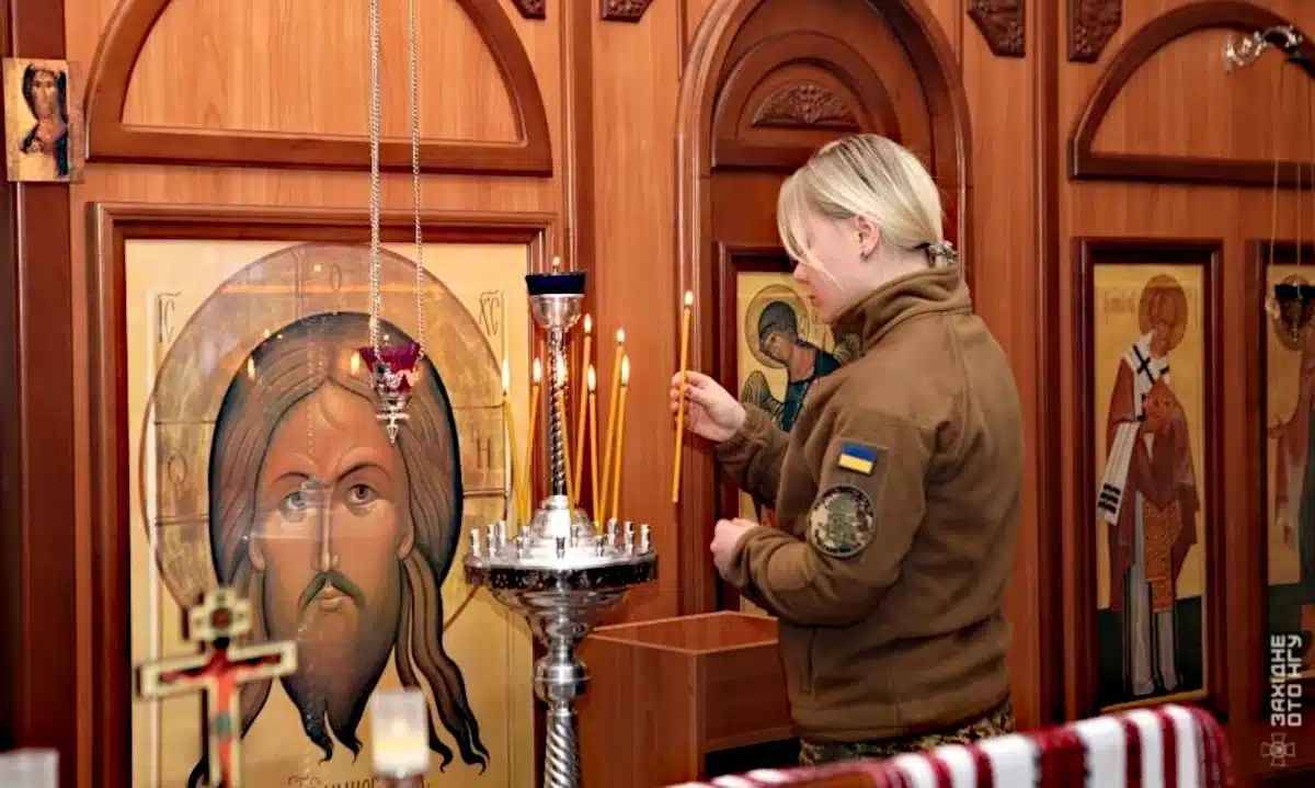 Спільна молитва й освячення води – як рівненські нацгвардійці зустріли Хрещення Господнє Нацгвардійка ставить свічку в капличці у Рівному.