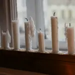 Погашені свічки стоять рядочком на підвіконні.