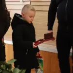 Малий хлопець отримує батькову нагороду.