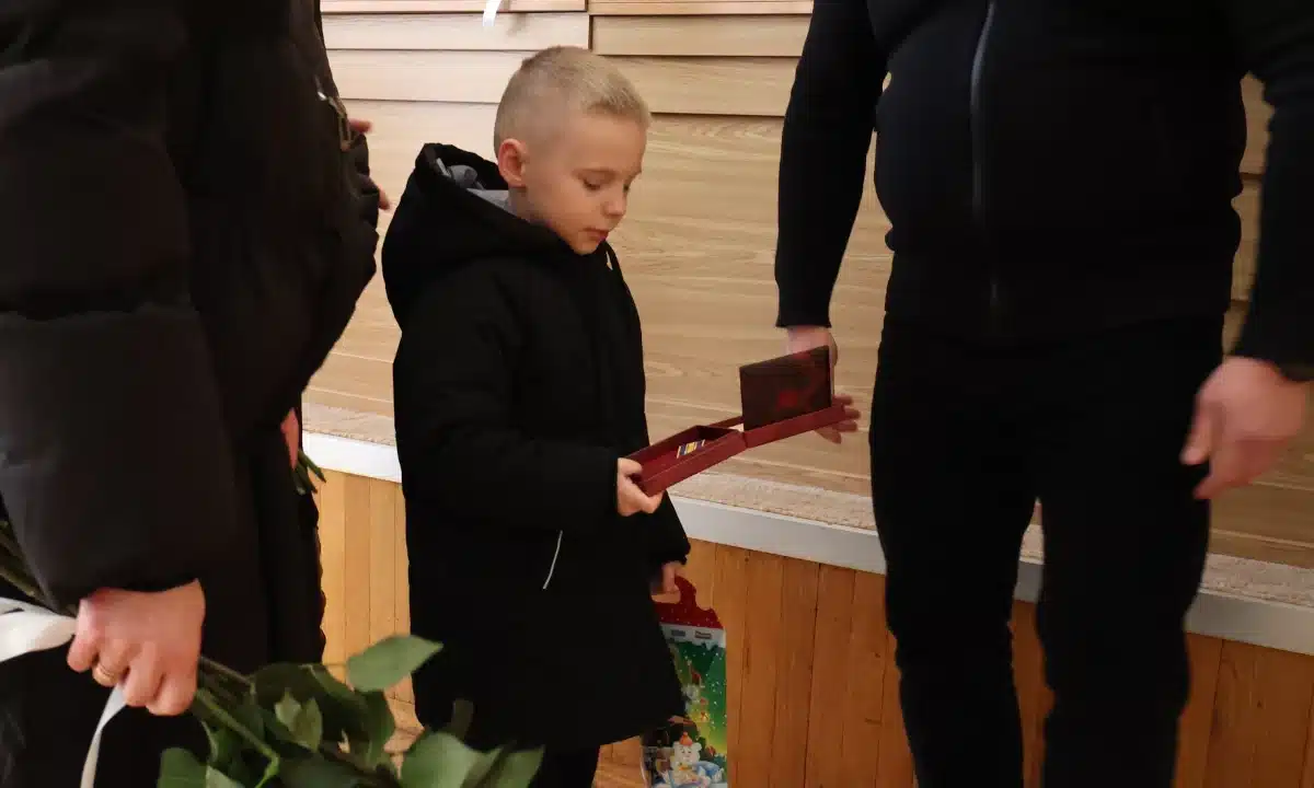 Малий хлопець отримує батькову нагороду.