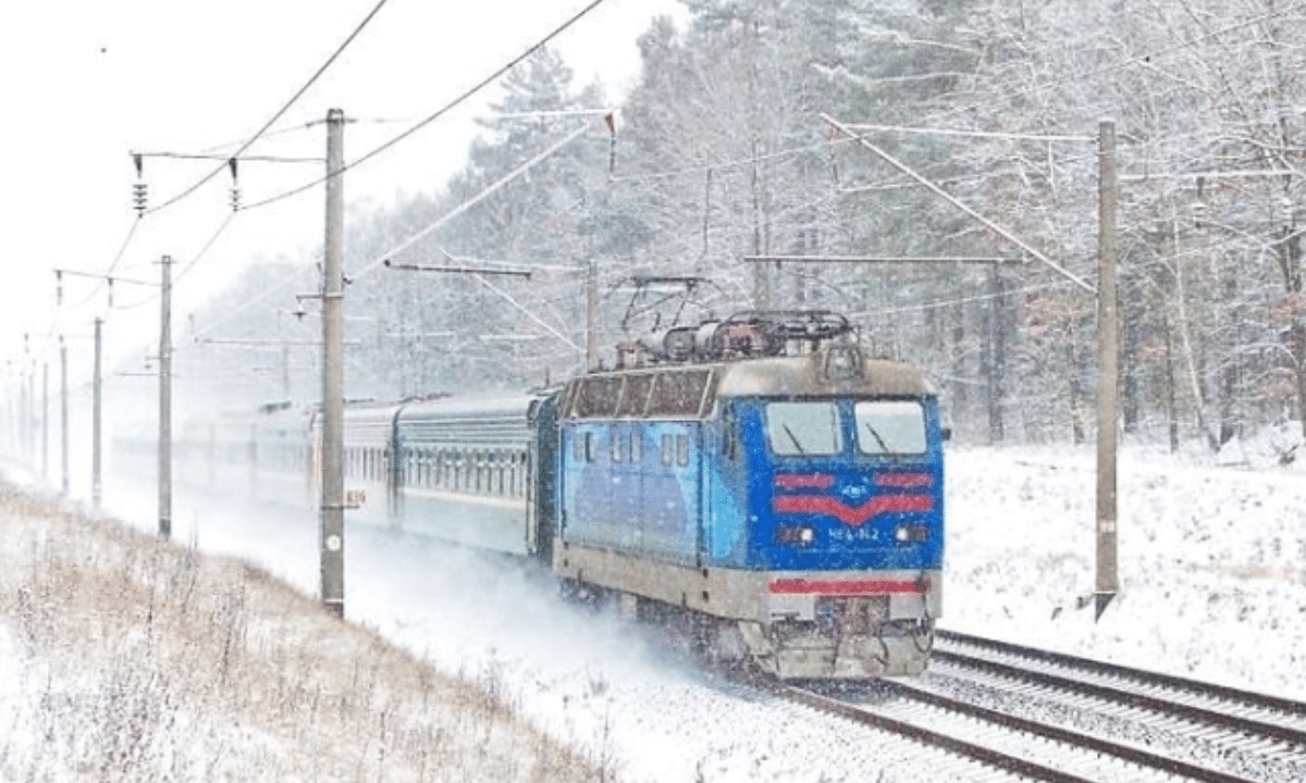 Потяг Укрзалізниці на залізничній станції під час складних погодних умов