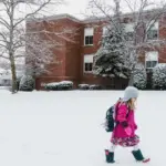 Діти йдуть до школи по снігу.