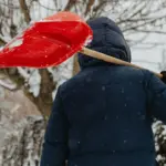 Чоловік з лопатою для снігу.