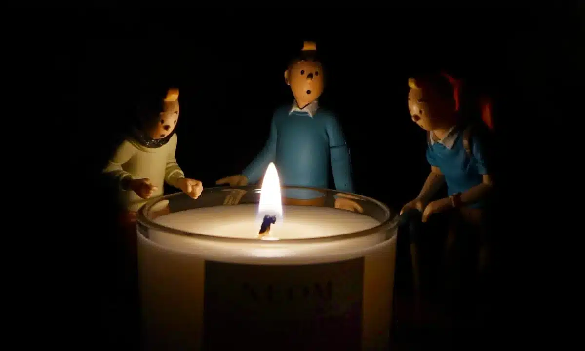 Горить свічка, навколо іграшкові фігурки людей.