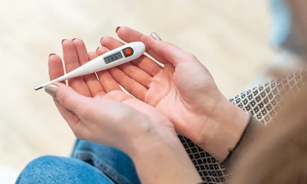 Електронний градусник у руках