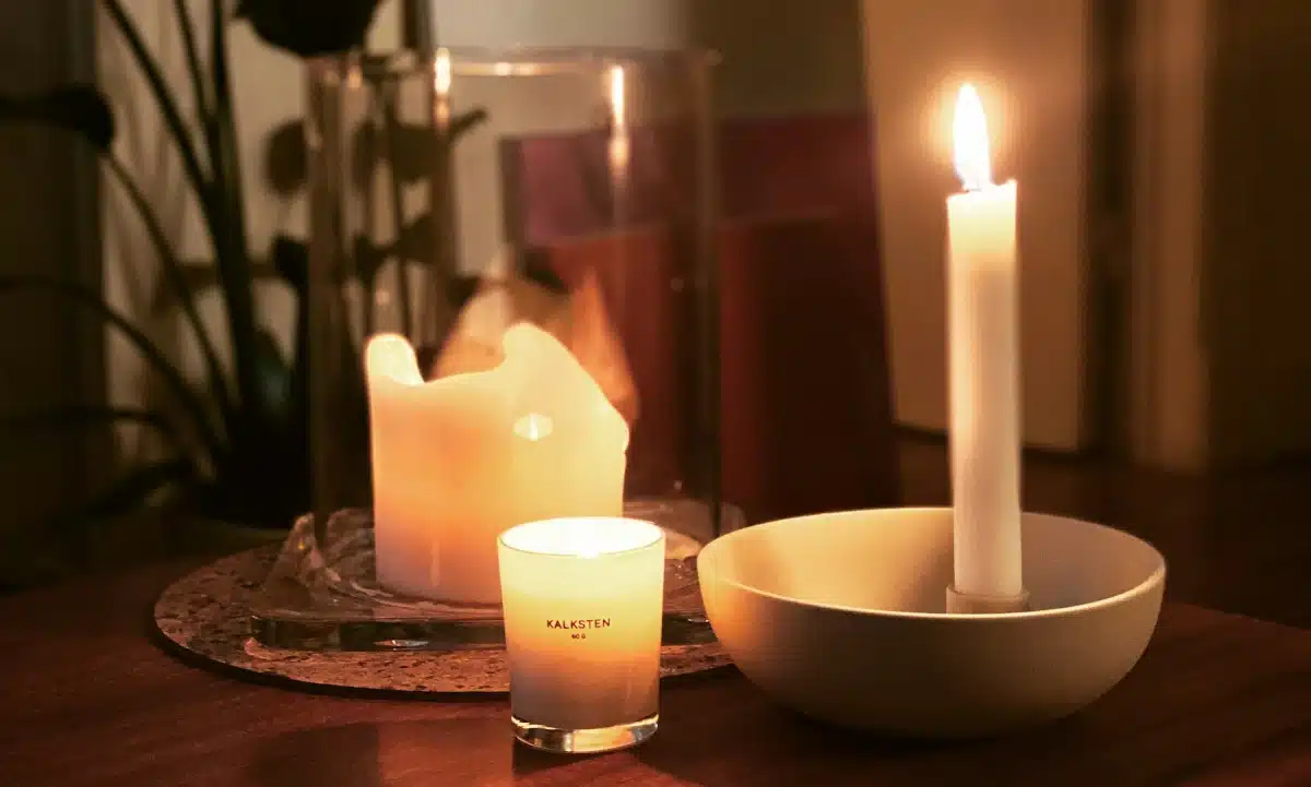 Три запалені свічки на столі.
