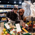 Покупці обирають овочі та фрукти в супермаркеті