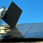 Чоловік встановлює сонячні панелі.