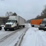 Вантажівки на засніженій дорозі.