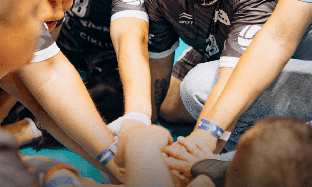 Учасники у спортивній формі зібрали руки разом перед початком занять у межах програми «Ветеранський спорт».