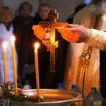 Священник освячує воду.