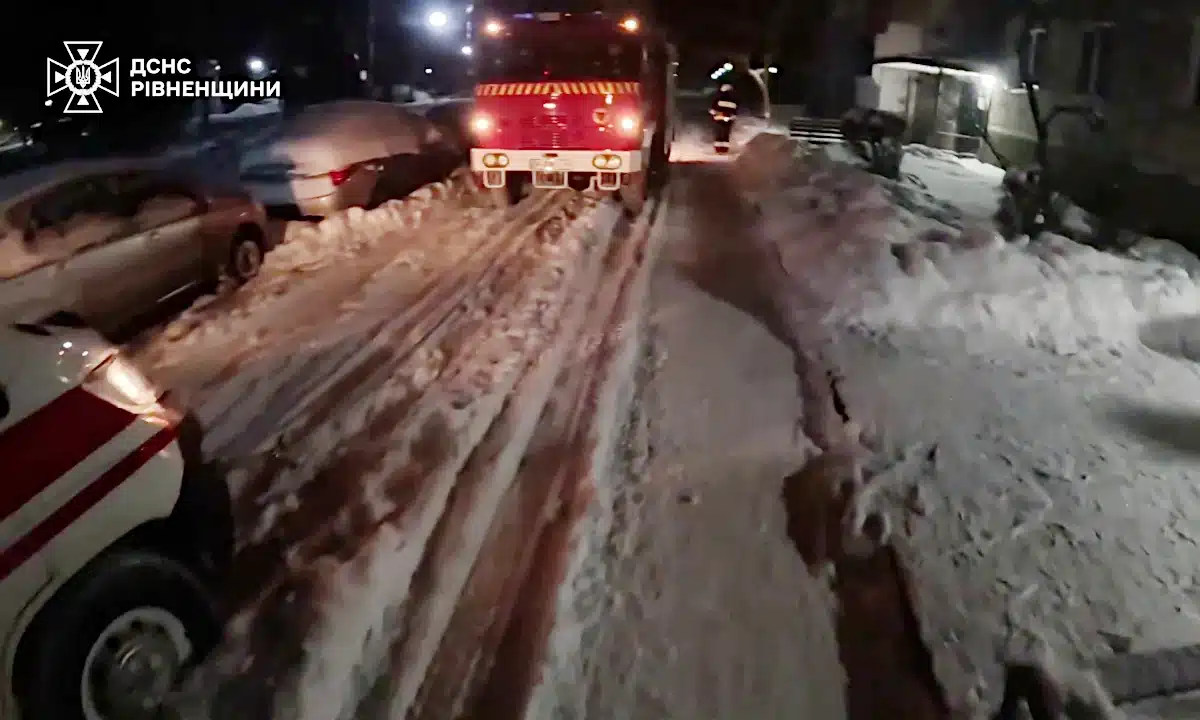 Рятувальники витягають швидку зі снігу.