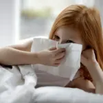 Дитина із ГРВІ прочищає носа.