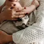 Мама тримає немовля на руках.