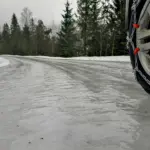 Обмерзла дорога, на ній видно колеса з цепами.