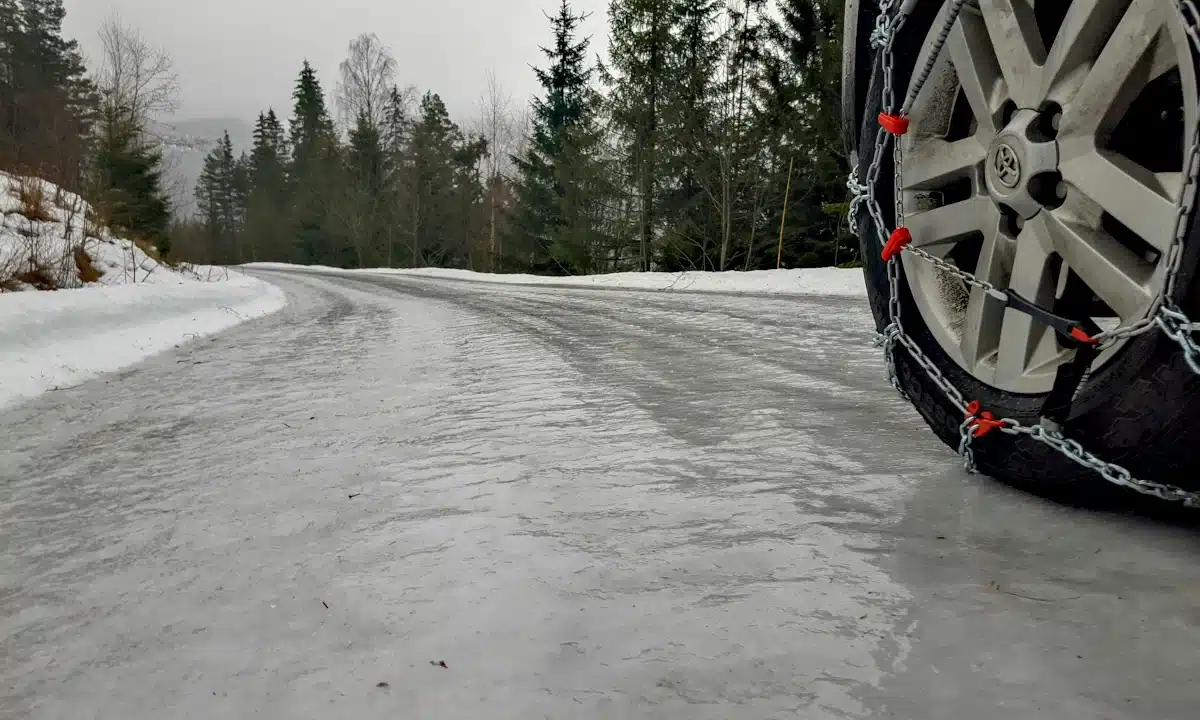 Обмерзла дорога, на ній видно колеса з цепами.