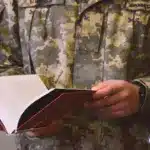 Військовий тримає книгу в руках.