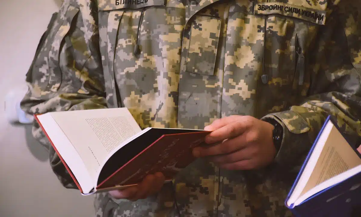 Військовий тримає книгу в руках.