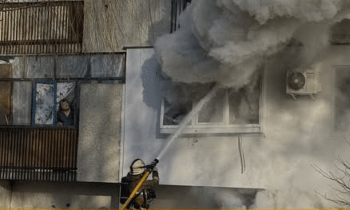 Рятувальник гасить пожежу на балконі.