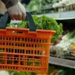 В супермакеті. У кошику лежить головка зеленого салату.