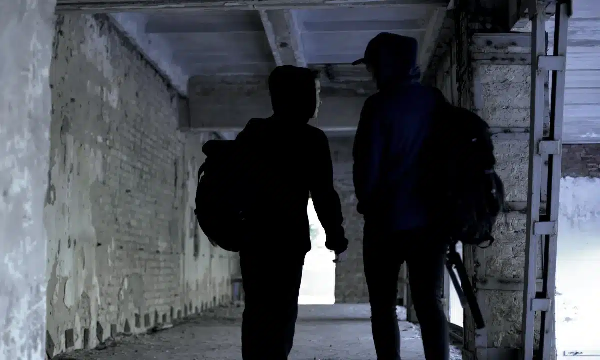 Два підлітки втекли зі школи і йдуть у закинутій будівлі.