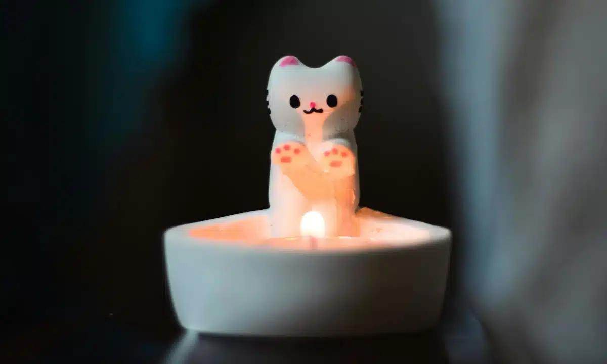 Запалена декоративна свічка-котик.