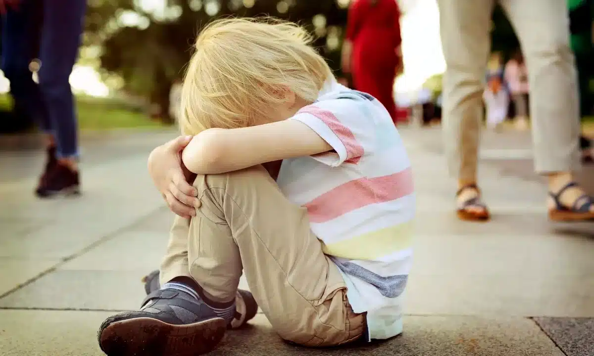 У Рівному за пів години зникли троє дітей Хлопчик сидить на підлозі з покладеною на коліна головою.