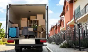 Вантажівка біля будинку із завантаженими меблями.