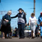 Переселенців зустрічають на пероні поліція і працівники Червоного Хреста.