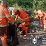Працівники прибирають сміття.