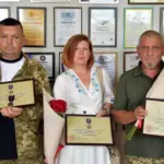 Двоє військових з нагородами, і дружина військового з його нагородою.