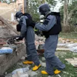 Рятувальники оглядають місце влучення безпілотника.